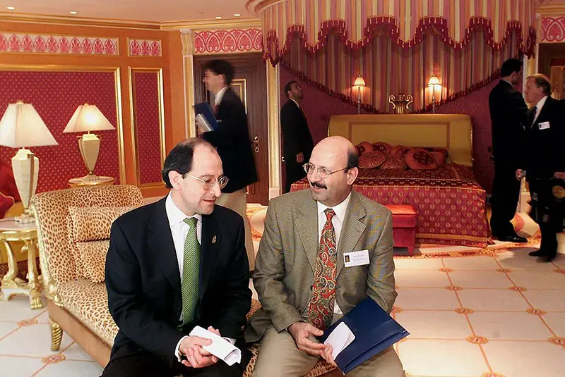 Philippe Charraudeau (L), General Manager of Dubai's latest luxury hotel Burj al Arab, talks to a visitor while journalists look at the bedroom of the royal suite, 28 November 1999, during a preview to the media ahead of the official opening, scheduled for December 1. (Photo credit JORGE FERRARI/AFP via Getty Images)