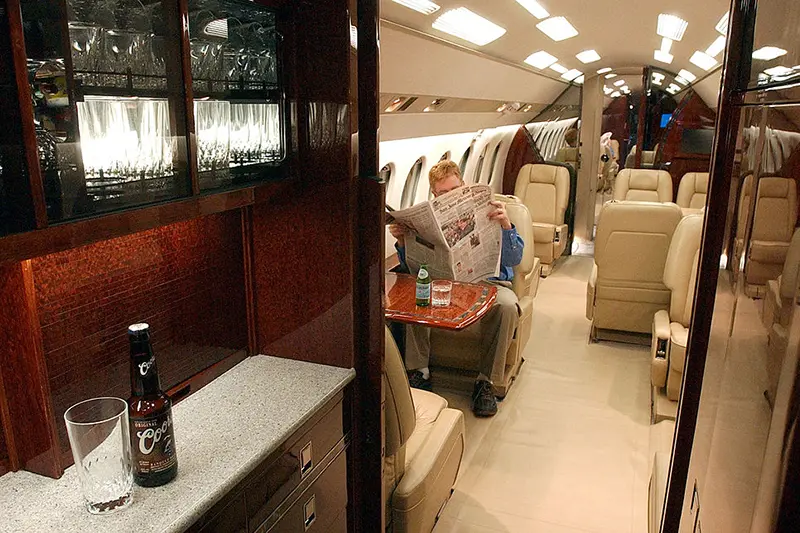 A man reads a newspaper aboard a private jet at ACM Aviation in San Jose, CA.