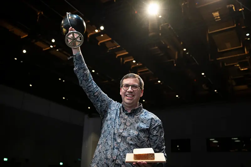 Swiss cheesemaker Pius Hitz from the Vorderfultigen cheese company lifts the trophy after winning the World Cheese Awards, after the final of the 37th World Cheese Awards, at the Festhalle in Bern, Switzerland, Thursday, Nov. 13, 2025. (Anthony Anex/Keystone via AP)