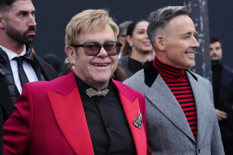 Elton John, center, and David Furnish, right, depart the Valentino Spring/Summer 2026 Haute Couture collection presented in Paris, Wednesday, Jan. 28, 2026. (AP Photo/Aurelien Morissard)