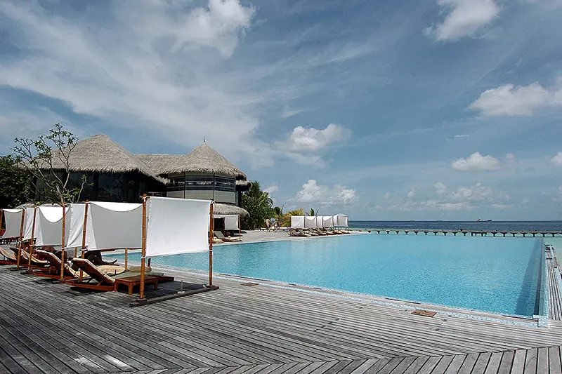 Tourists relax by a swimming pool adjoining the Indian Ocean at the plush Coco Palm resort on the Boduhithi Island, Maldives. (Photo credit should read LAKRUWAN WANNIARACHCHI/AFP via Getty Images)