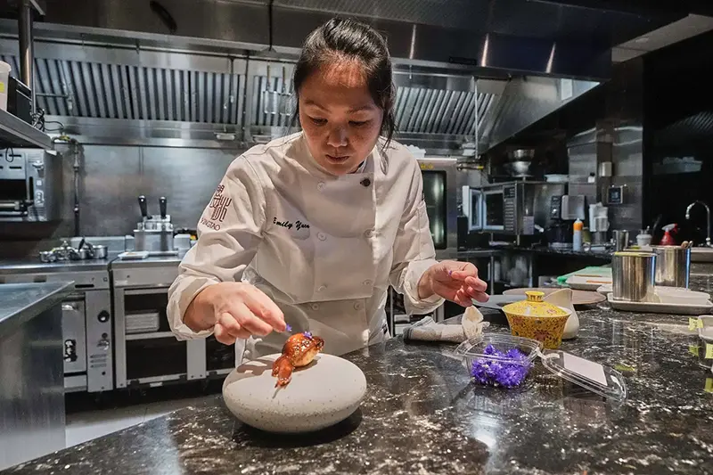 Emily Yuen, chef at Michelin-starred Chinese restaurant Yingtao, prepares Lo Mai Gai, sticky rice chicken in New York, Tuesday, Jan. 27, 2026. (AP Photo/Richard Drew)