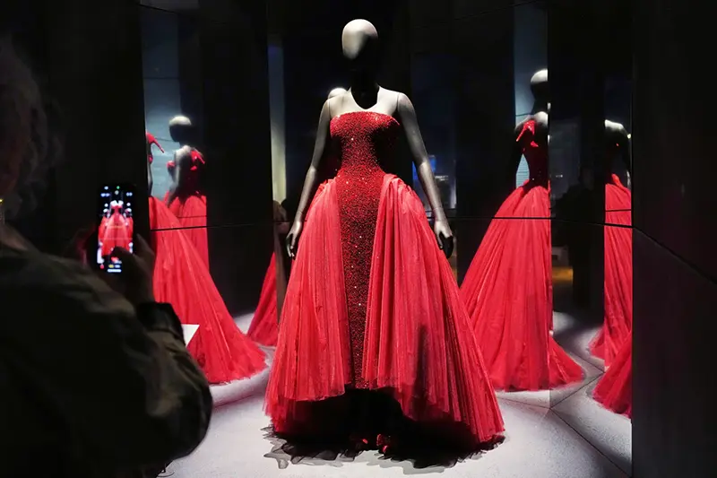 A visitor takes a picture of a gown worn by Ariana Grande at the 2025 Oscars, during the press preview for Schiaparelli: Fashion Becomes Art exhibition at the V&A museum in London, Wednesday, March 25, 2026. (AP Photo/Kirsty Wigglesworth)