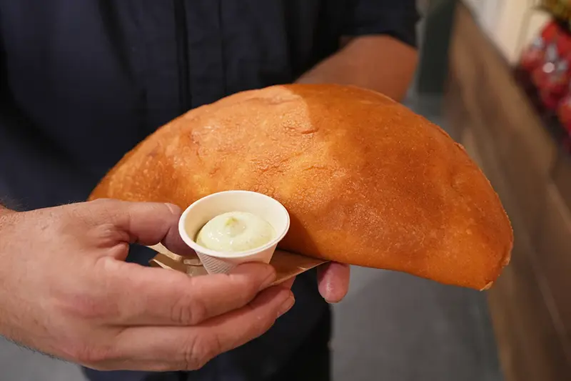 Lazaro Luya, the concession chef at Sol Cubano, displays their special, empanada mundial at Miami Stadium Sunday, June 21, 2026, in Miami Gardens, Fla. (AP Photo/Marta Lavandier)