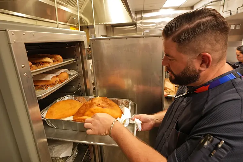 Lazaro Luya, the concession chef at Sol Cubano, displays their special, pan with lechon and fresh mariquitas at Miami Stadium Sunday, June 21, 2026, in Miami Gardens, Fla. (AP Photo/Marta Lavandier)