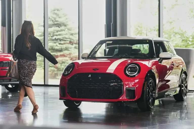 A shopper passes by an unsold 2026 Cooper S John Cooper Works 1965 Victory Edition hardtop on display in the showroom of a Mini dealership Friday, June 26, 2026, in Highlands Ranch, Colo. (AP Photo/David Zalubowski, File)