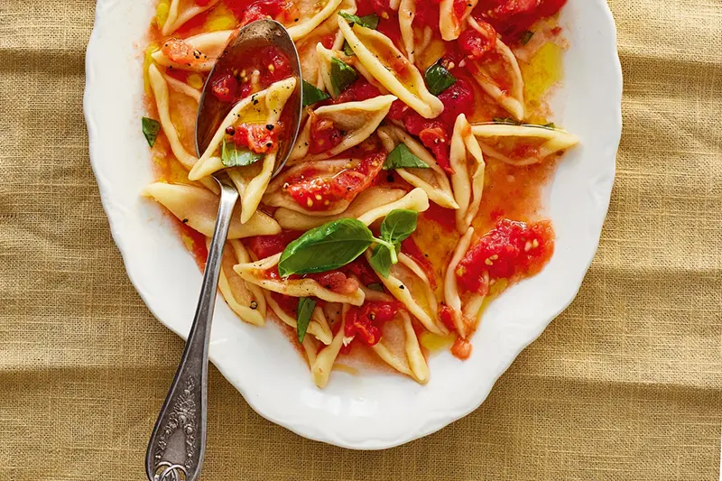 This image released by Voracious shows a recipe for no-cook tomato sauce from “Pasta Every Day” by Meryl Feinstein. (Nico Schinco/Voracious via AP)