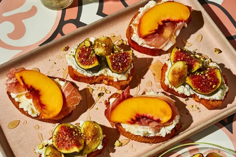 This image released by Voracious shows a recipe for crostini with seasonal fruit, ricotta, and honey from the cookbook “Stuzzichini” by Stef Ferrari. (Deepi Ahluwalia/Voracious via AP)